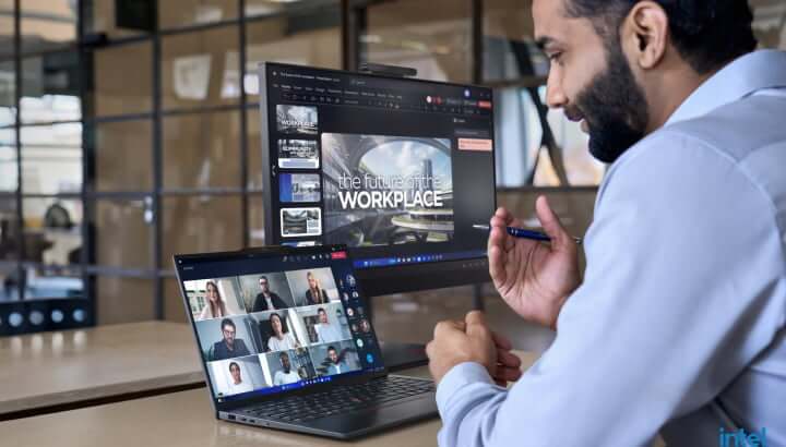 Man at table having online conversation via laptop