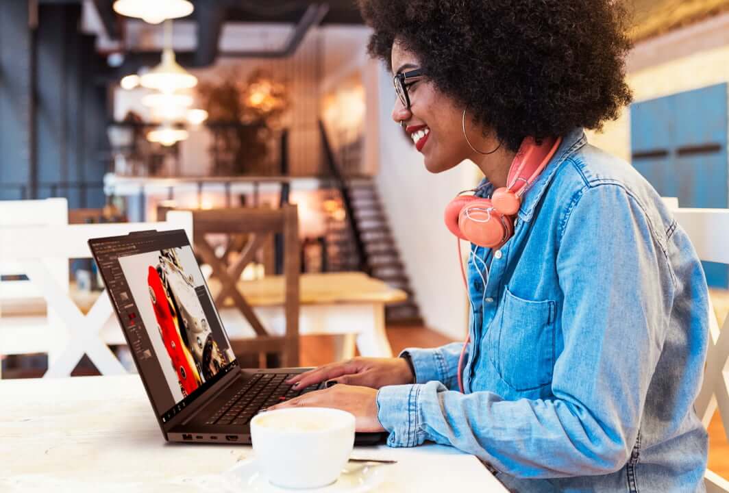 Woman sitting at a table in a cafe with a laptop